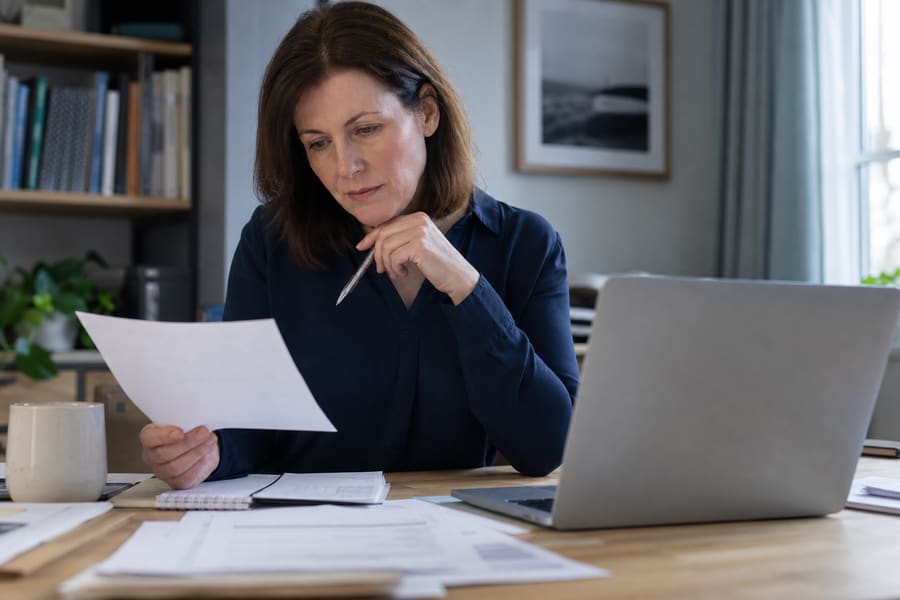 A UK specialist reviewing household paperwork at a desk